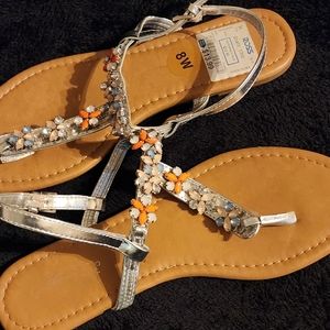 A flowery sandals with gems on the front of the sandal